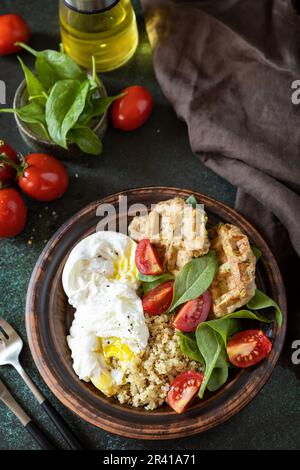 Vegane Zucchini-Waffeln, pochiertes Ei, Quinoa und frischer Gemüsesalat auf einem Steintisch. Keto-Diät. Köstliches Frühstück oder bru Stockfoto