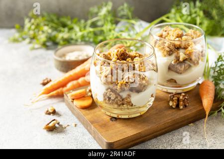 Veganes glutenfreies Backen. Karottenkuchen mit Walnüssen und Zimt in einem Glas auf hellem Hintergrund. Gesundes Dessert. Speicherplatz kopieren. Stockfoto