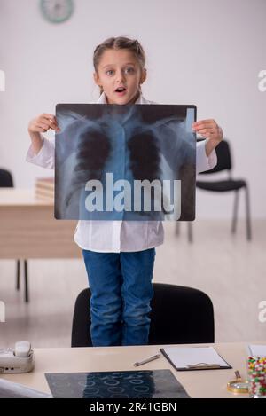 Kleines Mädchen, das Ärztin und Radiologin in der Klinik spielt Stockfoto