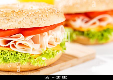 Sandwich mit Bagel-Brötchen zum Frühstück, garniert mit Hühnerschinken aus nächster Nähe in Stuttgart Stockfoto