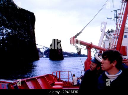 Grahamland Antarktis 1972 Fahrt zur Deception Island während der jährlichen hydrografischen Untersuchung der Antarktis mit HMS Endurance gegen dunkelblaues Meer und bewölkten Himmel Stockfoto