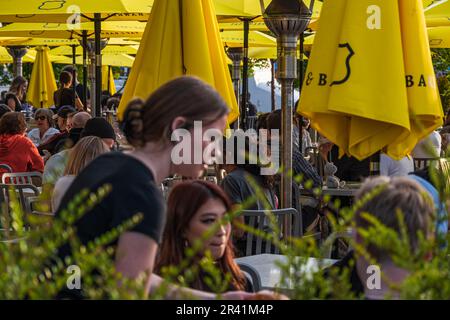 Street Bar Restaurant im Freien. Die Leute essen in einem Terrassenrestaurant zu Mittag, entspannte, freundliche Momente, Lebensstil. Die Gäste sitzen an Tischen in a t Stockfoto