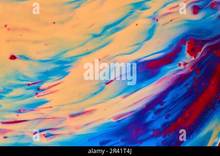 Farbenfrohe abstrakte Sanddünen, die Sand in blaue und rote Gewässer verwandeln Stockfoto