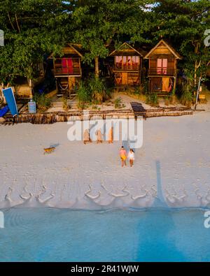 Ein paar Männer und Frauen, die am Strand von Koh Lipe Thailand spazieren Stockfoto