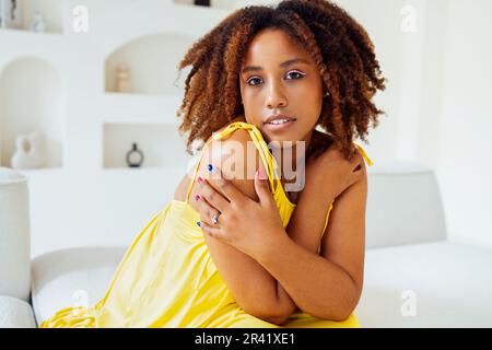 Wunderschöne, kurvige, übergroße junge afto-amerikanische Frau in einem gelben Kleid Stockfoto