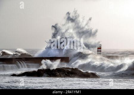 Wellen stürzen auf den alten Leuchtturm. Farolim de Felgueiras, Porto, Portugal. Stockfoto