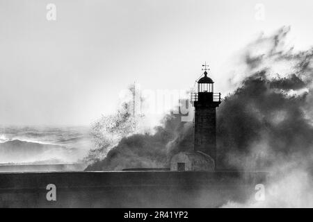 Wellen stürzen auf den alten Leuchtturm. Farolim de Felgueiras, Porto, Portugal. Stockfoto