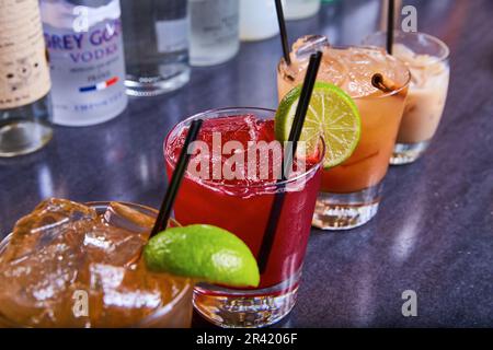 Tequila margarita Flug Cranberry Wodka Alkohol Getränke bunte Sammlung schwarze Strohhalme auf Eis Stockfoto