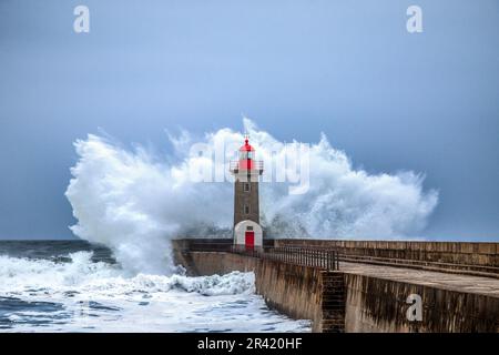 Wellen stürzen auf den Leuchtturm am Strand. Farolim de Felgueiras, Porto, Portugal Stockfoto