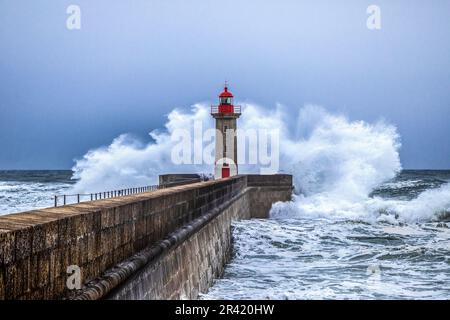 Wellen stürzen auf den Leuchtturm am Strand. Farolim de Felgueiras, Porto, Portugal Stockfoto