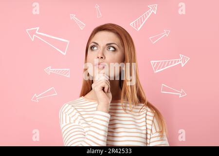 Berufswahl oder andere Lebensbereiche, Konzept. Entscheidungen treffen, eine aufmerksame Frau, umgeben von gezeichneten Pfeilen auf pinkfarbenem Hintergrund Stockfoto