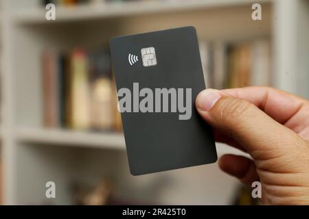 Schwarze kontaktlose Kredit- oder Debitkarte mit kontaktlosem Schild. Digitales Zahlungssystem. Stockfoto