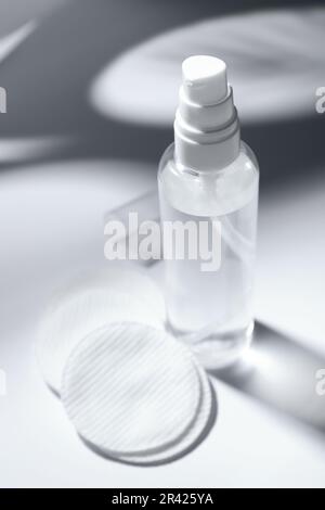 Flasche Mikellarwasser und Wattepads auf dem weißen Tisch Stockfoto