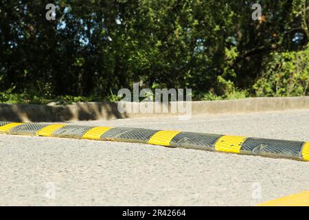 Bodenschwelle auf Asphaltstraße in der Nähe von Bäumen im Freien Stockfoto