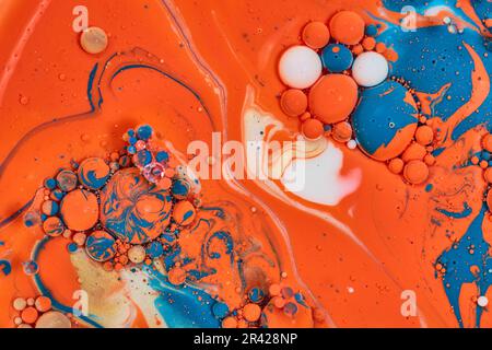 Abstrakter Orangensee mit blauen und weißen Blasen und goldenem Ölteppich als horizontales Hintergrundmaterial Stockfoto