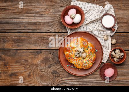 Zusammensetzung mit leckerem italienischen Osterbrot, Eiern und Milch auf Holzhintergrund Stockfoto