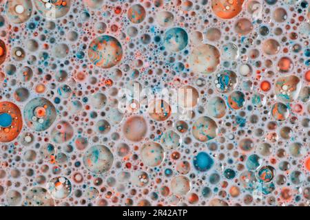 Horizontales Hintergrundmaterial mit abstraktem Raum und Kosmos voller bunter Welten und Sternen, die aus Milchöl und Farbe geschaffen wurden Stockfoto