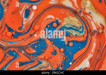 Verwirbeltes Ölteppich abstrakte Lackierung mit goldblauer und orangefarbener Acrylfarbe im horizontalen Hintergrund Stockfoto