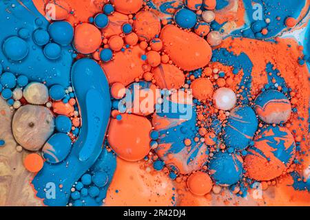 Wirbelnde Farben von blauem Gold und orangefarbenen Kugeln in abstrakter Hintergrundmalerei Stockfoto