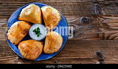 Zusammensetzung mit einem Teller aus im Ofen gebackenen Pierogi Stockfoto