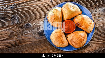 Zusammensetzung mit einem Teller aus im Ofen gebackenen Pierogi Stockfoto