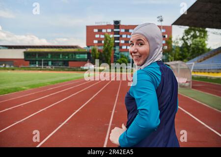 Eine muslimische Frau in einer Burka sportlich muslimische Kleidung, die auf einem Marathonkurs läuft und sich auf die nächsten Wettkämpfe vorbereitet Stockfoto