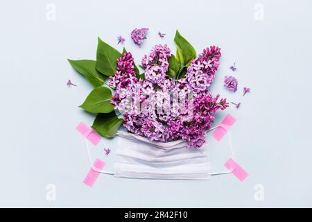 Danke Doktor und Schwestern Konzept mit medizinischer Maske und Fliederblumen auf blauem Hintergrund Stockfoto