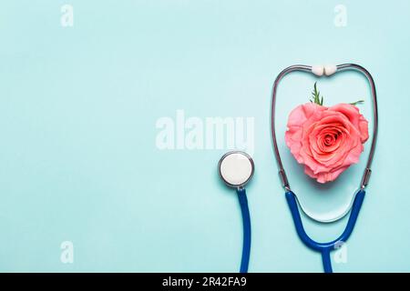 Stethoskop und schönes Rosenherz auf blauem Hintergrund. Danke, Doktor und Krankenpflegetag Konzept Stockfoto