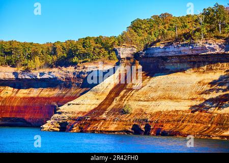 Schräge, rote goldene Steinfelsen im Pictured Rocks National Park Lake Superior Michigan mit Saphirwasser Stockfoto