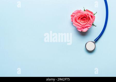 Schönes Rosenherz und Stethoskop auf blauem Hintergrund. Danke, Doktor und Krankenpflegetag Konzept Stockfoto