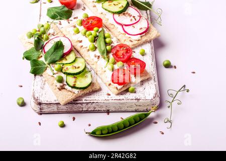 Gesunde Sandwiches mit Weichkäse und rohem Gemüse auf knusprigem Brot Stockfoto