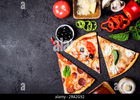 Auswahl an Pizza mit verschiedenen Stücken auf schwarzem Hintergrund und Zutaten. Pepperoni, vegetarische und Meeresfrüchte-Pizza Stockfoto