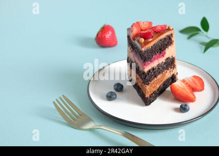 Köstlicher Schokoladenkuchen mit frischen Beeren. Abgeschnittenes Stück Kuchen auf dem Teller Stockfoto