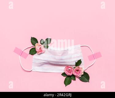 Dank Doctor and Nurses Konzept mit medizinischer Maske und Rosen Blumen auf rosa Hintergrund mit Copy Space Stockfoto