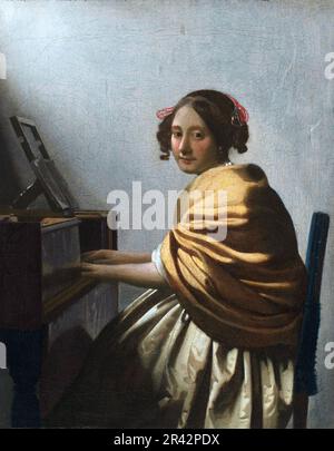 Eine junge Frau, die auf der Jungfrau sitzt, die 1670-1672 vom niederländischen Maler des Goldenen Zeitalters Johannes Vermeer gemalt wurde Stockfoto