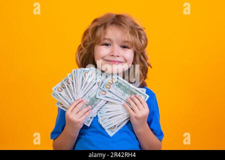 Der Junge hat viele hundert Dollar isoliert auf gelbem Hintergrund. Stockfoto