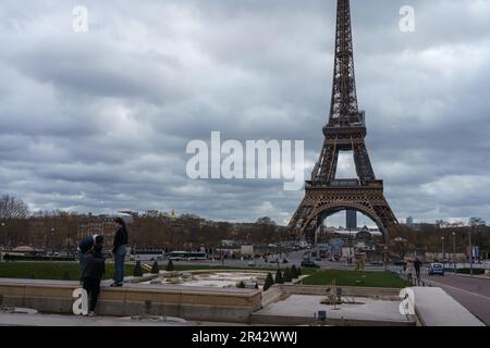 Touristen in den Trocadero-Gärten (Jardins du Trocadero) an einem bewölkten Tag mit Eiffelturm. Paris, Frankreich. 25. März 2023. Stockfoto