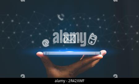 Weibliche Hand mit Smartphone, Kontaktieren Sie uns Verbindungskonzept. Kontaktieren Sie uns oder die Hotline des Kundensupports. Kontaktsymbole auf virtuellem Bildschirm ( ema Stockfoto