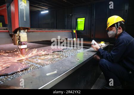 NANTONG, CHINA - 26. MAI 2023 - Ein Arbeiter baut eine Laserschneidemaschine für Fasern auf, um Rohstoffe automatisch zu schneiden in Nantong, Provinz Jiangsu, China, Stockfoto