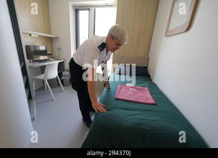 Ein Gefängnisbeamter passt die Bettwäsche in einem Zimmer im Iris House während eines Besuchs von Justizministerin Angela Constance bei der neuen HMP und YOI Stirling an. Die neu errichtete nationale Einrichtung für Frauen, die HMP & YOI Cornton Vale ersetzt, wird diesen Sommer eröffnet und ist ein wichtiger Meilenstein bei der fortlaufenden Umgestaltung des weiblichen Gefängnisbestands. Foto: Donnerstag, 25. Mai 2023. Stockfoto