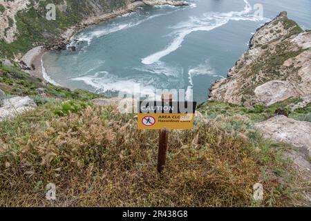 Ein Schild warnt Besucher vor gefährlichen Klippen und gefährlichen Wasserfällen am Potato Harbor Overlook im Channel Islands National Park, Kalifornien. Stockfoto