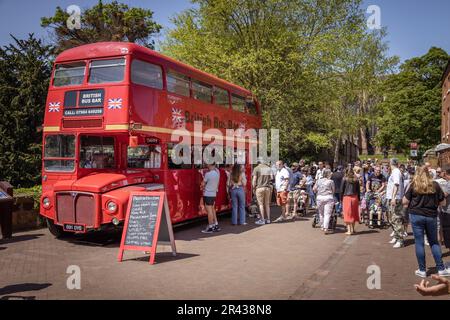 Gäste, die während des Lichfield Food Festivals in der British Bus Bar anstehen, einem umgebauten roten Doppeldeckerbus, um ein Getränk zu kaufen. Stockfoto