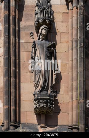 Eine Steinschnitzerei, die die Westfront der Kathedrale von Lichfield schmückt. Die Skulptur zeigt die heilige Werburga oder Werburgh, den schutzheiligen von Chester. Stockfoto