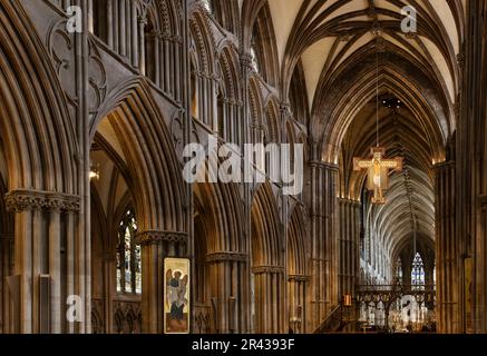 Ein Kreuz mit dem Bild von Jesus ist von der gewölbten Decke im herrlichen Inneren der Lichfield Kathedrale, Stockfoto