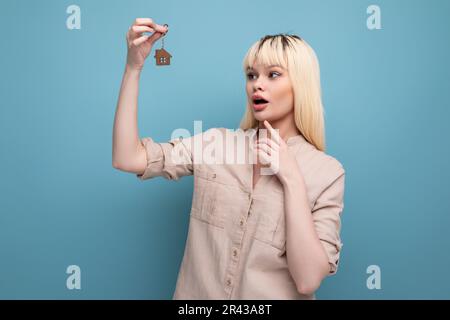 Eine junge Frau kaufte eine Wohnung und hielt einen Schlüsselanhänger mit Schlüsseln Stockfoto