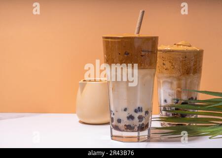 Boba dalgona Kaffee. Trendiges asiatisches Latte-Morgengetränk mit Instant-Kaffee und Tapioka-Perlkugeln, thailändisches Schaumcocktail-Glas im Sommer in der Sonne Stockfoto