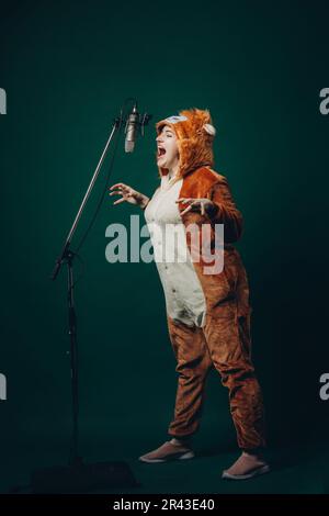 Die Frau bereitet sich und ein Material vor, bevor sie die Stimme aufnimmt. Schalldichter Raum für professionelle Stimmaufnahmen. Der Sprachkünstler arbeitet mit Material Befor Stockfoto