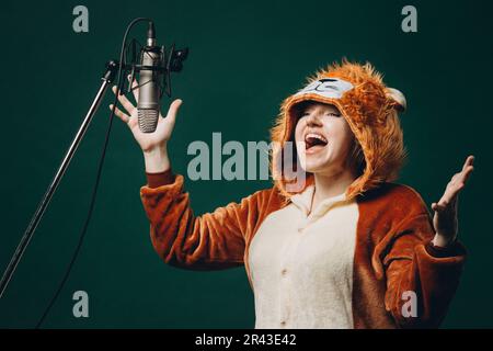 Die Frau bereitet sich und ein Material vor, bevor sie die Stimme aufnimmt. Schalldichter Raum für professionelle Stimmaufnahmen. Der Sprachkünstler arbeitet mit Material Befor Stockfoto