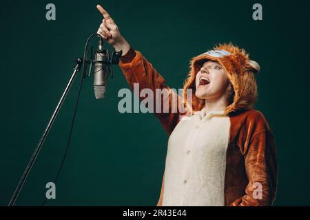 Die Frau bereitet sich und ein Material vor, bevor sie die Stimme aufnimmt. Schalldichter Raum für professionelle Stimmaufnahmen. Der Sprachkünstler arbeitet mit Material Befor Stockfoto