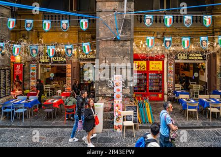 Neapel, Italien - 7. Mai 2023: Touristen in der Via dei Tribunali im historischen Zentrum von Neapel mit Geschäften und Restaurants im Hinterhof Stockfoto